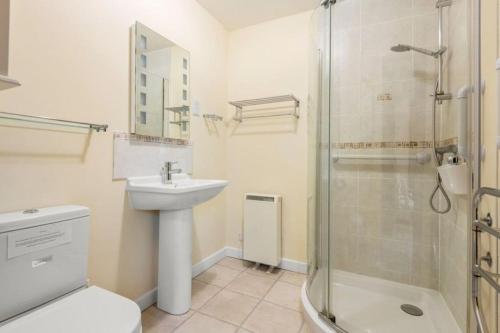 a white bathroom with a sink and a shower at Brook Barn in Malborough