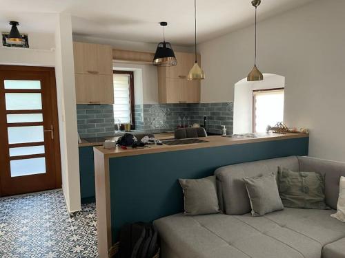 ein Wohnzimmer mit einem Sofa und einer Küche in der Unterkunft Morris Vacka in Veszprém