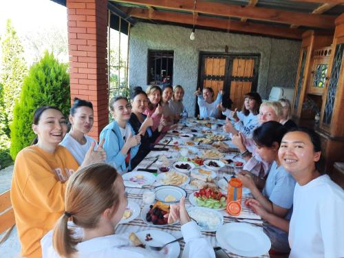 a group of children sitting around a long table eating food at Guest House Gardenia & Wine Cellar in Lagodekhi