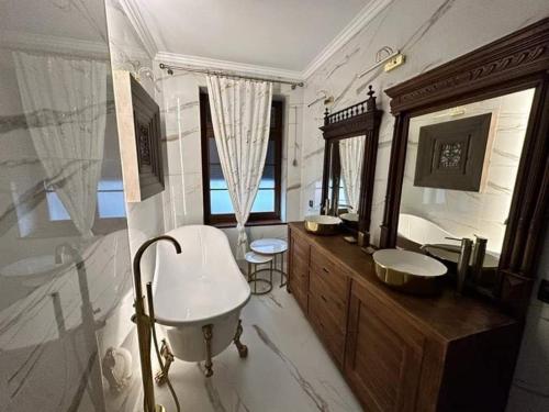a bathroom with a tub and a sink and a mirror at Apartament 511 Gold AC Progres in Toruń
