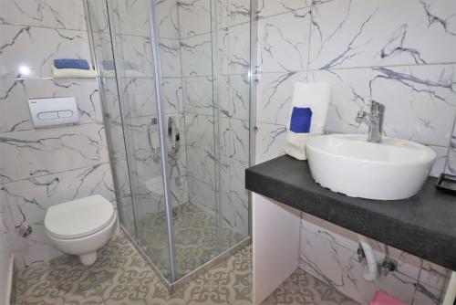 a bathroom with a shower and a sink and a toilet at Aymena A in Kuşadası