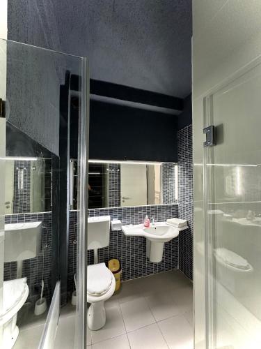 a bathroom with a toilet and a sink at Seaside Inn & Suites in Costinesti