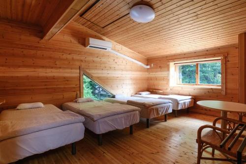 Habitación con 4 camas en una cabaña de madera en Yuki-no Hana Sansou, en Takashima