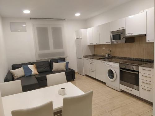 een keuken en een woonkamer met een bank en een tafel bij Apartment in Bilbao, comfortable and well equipped in Bilbao