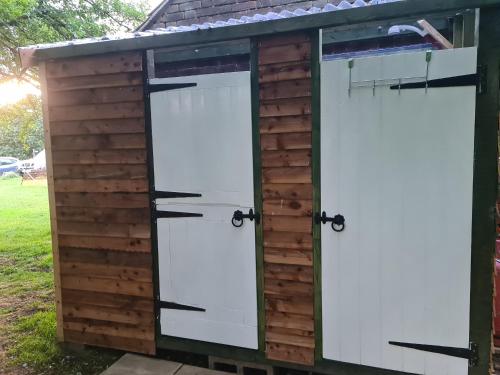 two white doors on a wooden shed at The Potting Shed in Manuden