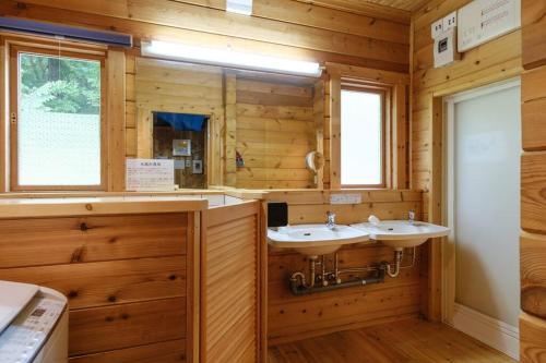 Baño con 2 lavabos en una cabaña de madera en Yuki-no Hana Sansou, en Takashima