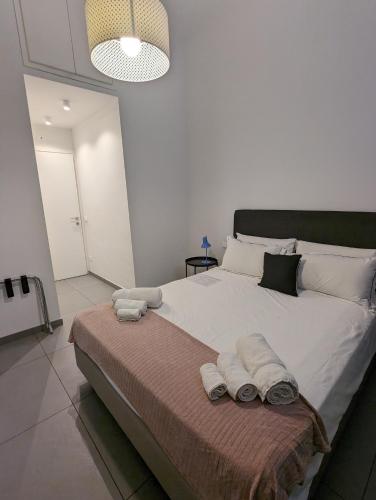 a bedroom with a large bed with towels on it at Zefiro Suites in Palermo
