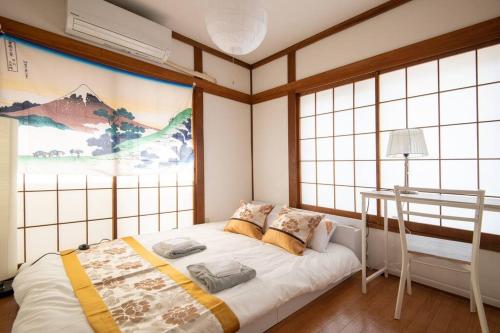 a bedroom with a bed in a room with windows at Rea東向島4丁目 in Tokyo