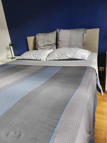 a bed in a room with a blue wall at Belle appartement T3 pour 5 personne max in Annecy