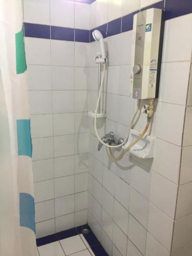 y baño con ducha y pared de azulejos blancos. en Sang Tong Huts, en Mae Hong Son