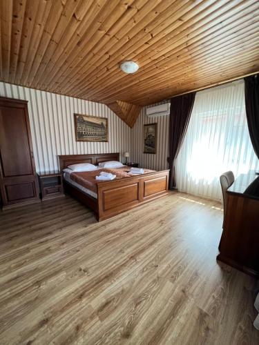 ダイダにあるGuest House Villa Lampertiの木製の天井が特徴のベッドルーム1室(ベッド1台付)