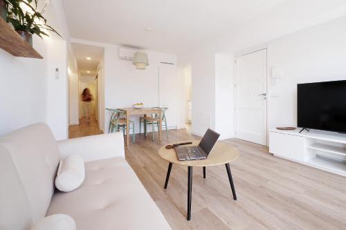 a living room with a couch and a laptop on a table at Porto Comfort in Porto Cristo