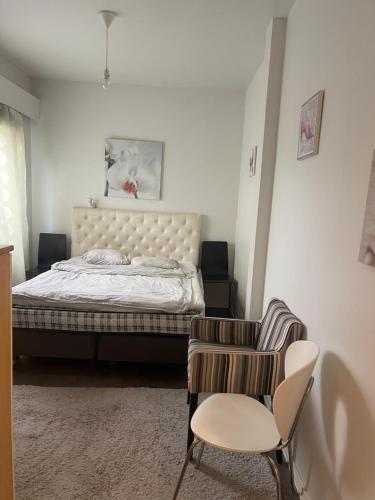 a bedroom with a bed and a chair at Yksiö 1 km jokirannasta föriltä/ 2 km torilta in Turku