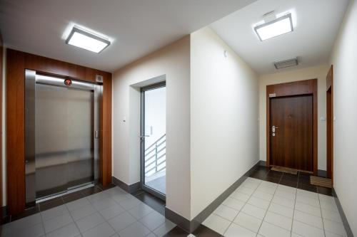 een hal met twee liften en een deur bij Wola Modern Apartment in Warschau