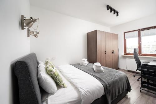a bedroom with a bed and a desk in it at Wola Modern Apartment in Warsaw