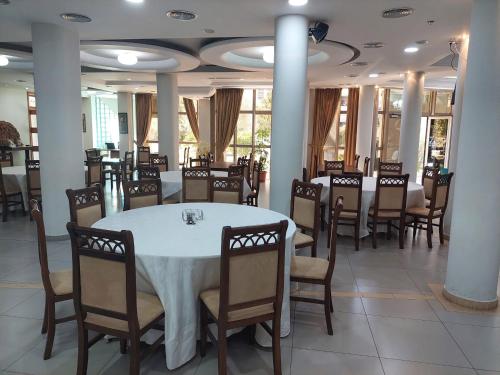 a dining room with a white table and chairs at Hotel Green in Tirana