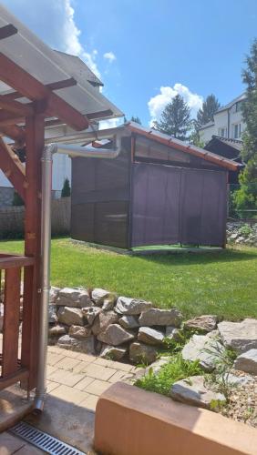 a backyard with a stone wall and a gazebo at Privát Szállás Miskolctapolca in Miskolctapolca