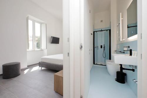 a white bathroom with a bed and a sink at Youroom Monteverde - Rooms in Rome