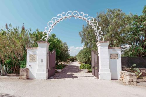 an entrance to a garden with an archway at Casale del Murgese Country Resort in Savelletri di Fasano