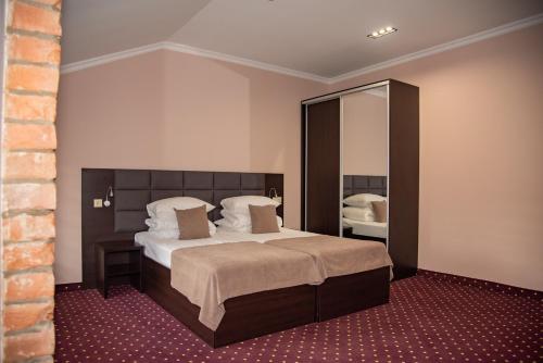 a bedroom with a large bed and a mirror at T&S Apart-Hotel in Chernivtsi