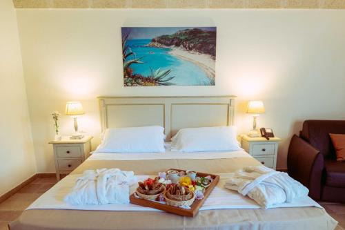 a bedroom with a bed with a tray of food on it at Casale del Murgese Country Resort in Savelletri di Fasano