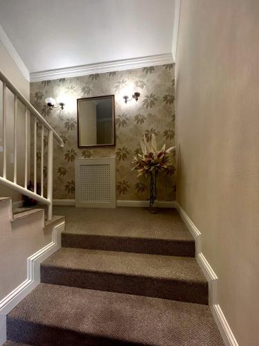 a staircase with a television and a vase of flowers at Hotel Forras in Komárom