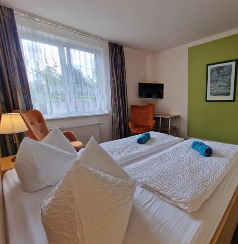 a bedroom with a bed with white sheets and a window at Spreewaldhotel Seerose in Burg