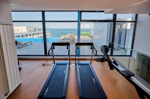 a gym with two treadmills and a swimming pool at VDR Holiday Apartment 139 in Infinity Beach Resort - parking in Mamaia