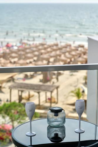 a glass table with two spoons and a vase on a table in front at VDR Holiday Apartment 139 in Infinity Beach Resort - parking in Mamaia