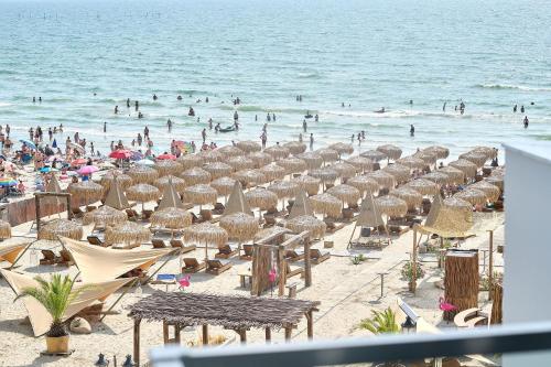 a beach with many umbrellas and people in the water at VDR Holiday Apartment 139 in Infinity Beach Resort - parking in Mamaia