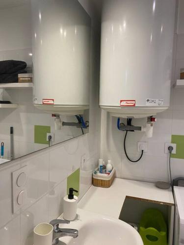 La salle de bains est pourvue d'un lavabo et d'un comptoir blanc. dans l'établissement Le péageois : Appartement lumineux et calme, à Bourg-de-Péage