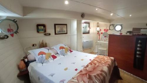 - une chambre avec un grand lit fleuri dans l'établissement Bateau Mariance, à Ginestas