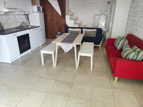 a living room with a red couch and a table at Appartement terasse in Saint-Maur-des-Fossés