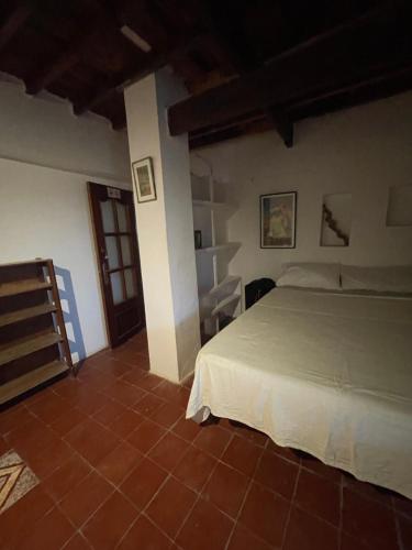 a bedroom with a white bed and a tiled floor at Dar el pirata in Asilah