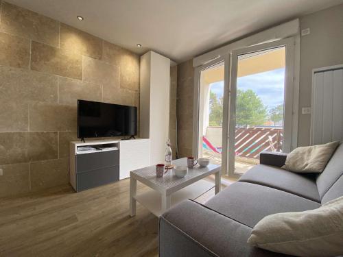 un salon avec un canapé et une télévision dans l'établissement Studio moderne avec balcon sud, parking privé, près avenue De Gaulle - 2 couchages à La Baule - FR-1-245-107, à La Baule