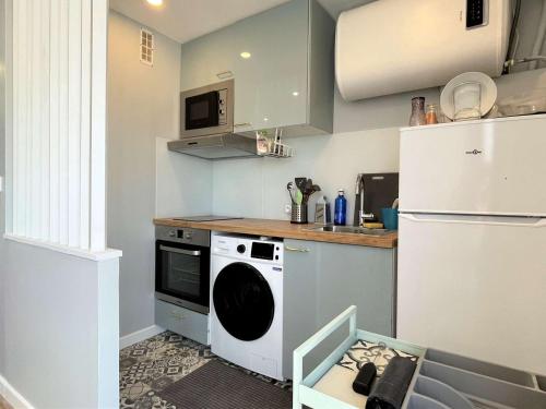 Il comprend une cuisine équipée d'un lave-linge et d'un réfrigérateur blanc. dans l'établissement Studio 4 pers à 2 min de la plage avec TV écran plat, Wifi, proches commerces - FR-1-229C-4, à Port-la-Nouvelle