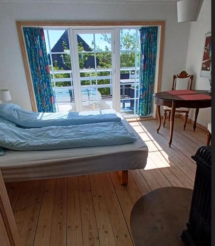 a bedroom with a bed and a sliding glass door at Skærbæk BB Bed and Bath in Skærbæk