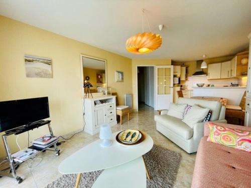 un salon avec un canapé et une table dans l'établissement Quiberon : Joli T2 avec Balcon Sud, Proche Plage et Centre-Ville - FR-1-478-255, à Quiberon