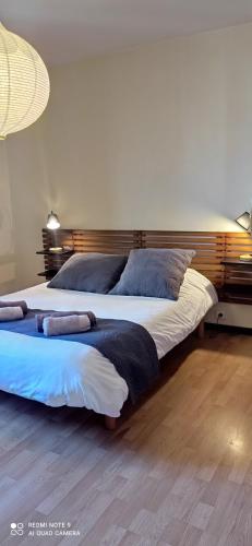 une chambre avec un grand lit avec deux oreillers dessus dans l'établissement La talonnière, maison de village avec terrasse et 3 chambres, à Messas