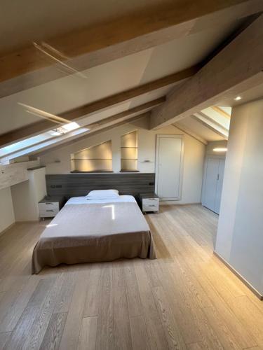 a large bedroom with a large bed and wooden floors at Hotel Ristorante del Peso in San Michele Mondovì