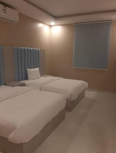 Tempat tidur dalam kamar di دانة القادسية للوحدات السكنية المفروشة