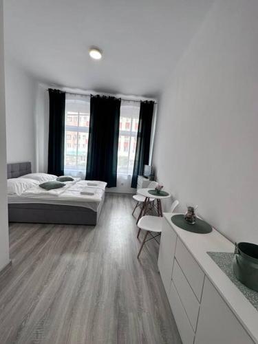 Großes weißes Zimmer mit einem Bett und einem Tisch in der Unterkunft Przytulny apartament in Szczecinek