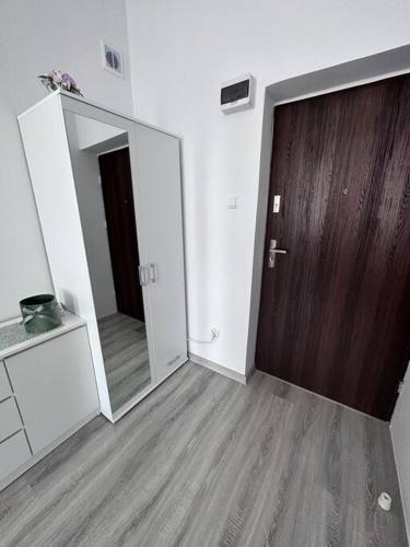 Zimmer mit Holztür und Spiegel in der Unterkunft Przytulny apartament in Szczecinek
