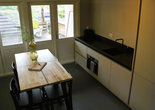 a small kitchen with a table and a sink and a counter at B&B Vechtzicht in Weesp