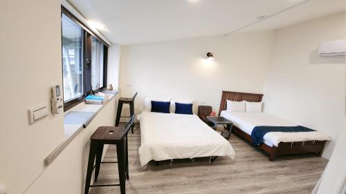 sypialnia z 2 łóżkami i oknem w obiekcie Stay if you wish Homestay w mieście Jiufen