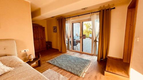 a living room with a couch and a sliding glass door at Der Hof am Wald in Weichselbaum