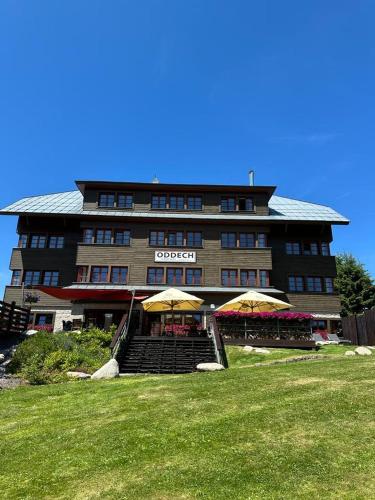 a large building with two umbrellas in front of it at Hotel Oddech in Pec pod Sněžkou