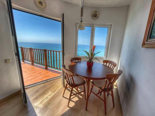 mesa de comedor con vistas al océano en Apartamento en acantilado con wifi y aire acondicionado, en Sitges