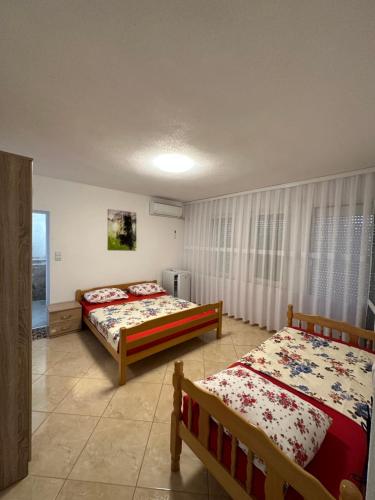 1 dormitorio con 2 camas y ventana en Apartments Edona en Ulcinj