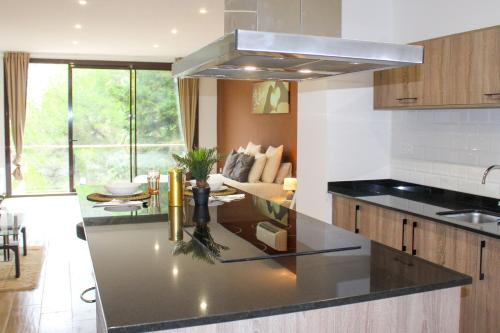 uma cozinha com um balcão preto e uma sala de estar em Barceló Apartaments em Monistrol